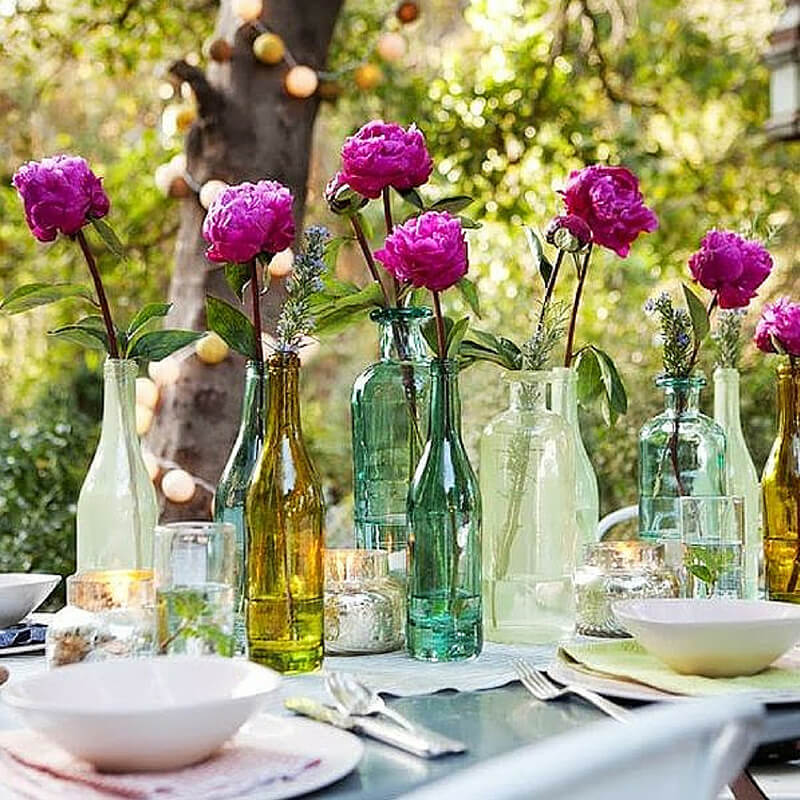 För att dekorera bordet för blommor kan till och med färgade flaskor installeras - det kommer att se ganska intressant