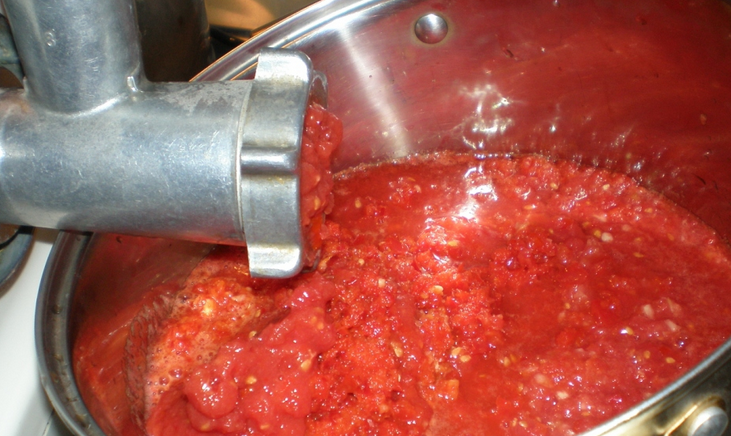 Hoppa över tomater genom en köttkvarn